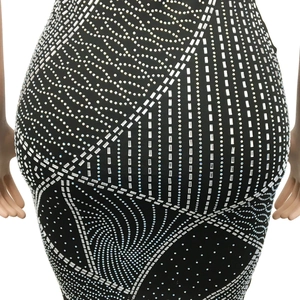 Détails de strass argentés et motifs géométriques complexes sur un tissu noir soyeux