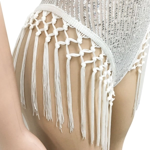 Détail de la frange blanche tissée main et sequins argentés sur le body de mode