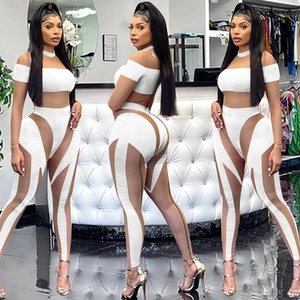 Detailansicht eines weißen Zweiteilers mit Mesh-Einsätzen an Crop-Top und High-Waist-Hose
