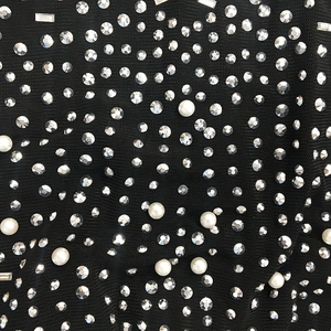 Détail macro de strass et perles sur tissu en maille noire pour robe de soirée chic
