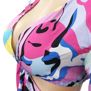 Détail de l'imprimé abstrait coloré et du décolleté en V profond sur cette robe chic