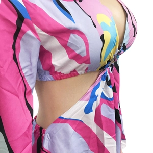 Détail de la découpe latérale et de l'imprimé abstrait coloré sur une robe à manches longues