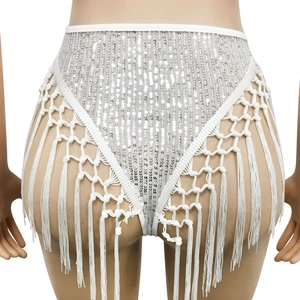 Vue détaillée des paillettes argentées et longues franges sur le combishort blanc