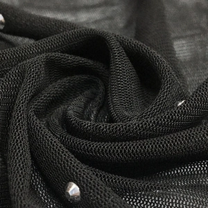 Detail of black mesh fabric featuring silver metallic studs for evening dress