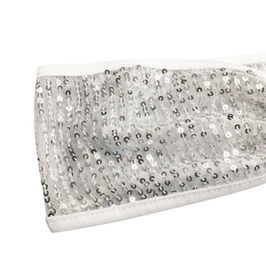 Gros plan détaillé montrant les paillettes argentées et la texture du tissu blanc