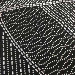 Gros plan de motifs en strass étincelants sur tissu noir pour une robe de soirée chic