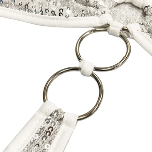 Détail macro du tissu blanc avec paillettes argentées et connecteurs anneaux