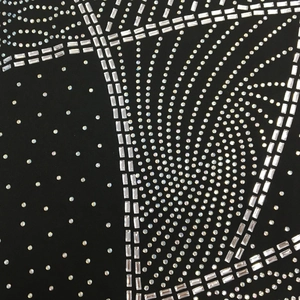 Détail du motif tourbillonnant en strass sur le tissu de la robe de soirée sexy