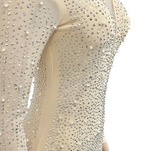 Gros plan de strass argentés et perles sur le tissu en tulle d'une robe de soirée
