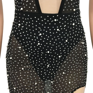 Detail eines schwarzen Partykleids mit Strasssteinen, Perlen und Mesh-Einsätzen