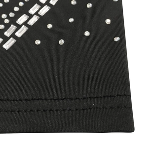 Détail de robe noire à strass montrant les paillettes argentées et l'ourlet à double aiguille
