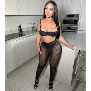 Detalle de conjunto negro de dos piezas de malla con pantalón transparente y top corto