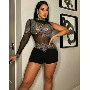 Détail d'un body en mesh noir avec des strass colorés formant un motif de vagues