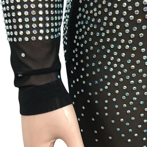 Close-up of black mesh dress featuring iridescent rhinestones and elastic ribbed cuffs