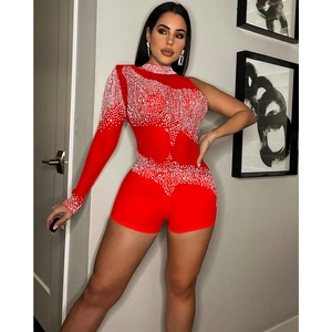 Détail du body rouge à une épaule orné de strass blancs brillants et tissu extensible