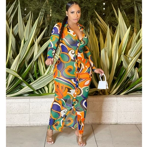 Detail of sheer mesh maxi dress with vibrant tropical leaf and paisley pattern print