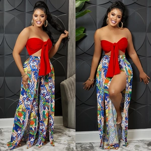Detail of red tube top with bow and high waist floral trousers featuring side slits
