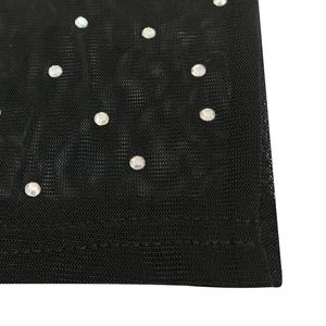 Close-up of black mesh fabric with shimmering rhinestones and fine stitching detail