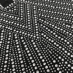 Detail-Nahaufnahme funkelnder silberner Strasssteine auf schwarzem sexy V-Ausschnitt Kleid
