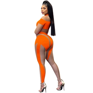 Detail eines sexy orangefarbenen Mesh-Jumpsuits mit Neckholder-Top und transparenter Hose