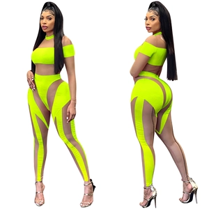 Neongrünes Set aus bauchfreiem Oberteil und Hose mit transparenten Mesh-Einsätzen