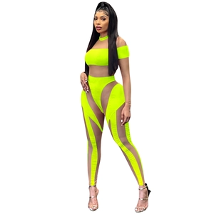 Details des neongelben Mesh-Jumpsuits mit transparenten Ausschnitten und Ärmeln