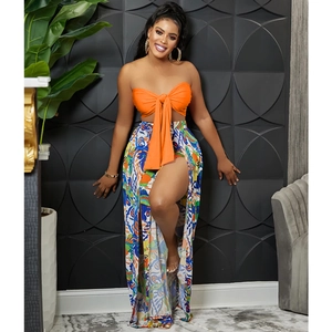 Detail of the orange bow tube top and vibrant floral slit pants on a female model