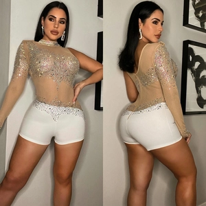 Détail d'un body en mesh transparent avec strass colorés et manche longue asymétrique