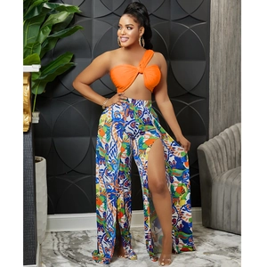 Detail of fashion two-piece set featuring orange crop top and high-waist split print pants