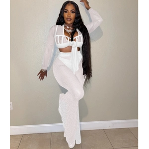 Detailed view of white mesh two-piece set featuring pearl embellishments and lace-up top