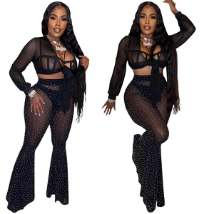Detail of black mesh two-piece set with shimmering rhinestones and lace-up V-neck top