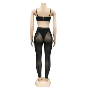 Detalle de los pantalones de malla negra y top con cremallera en la espalda en maniquí