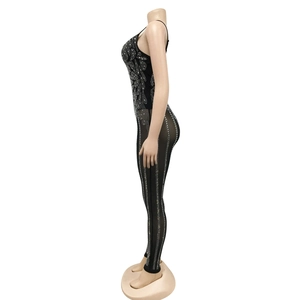 Close-up of sheer mesh jumpsuit featuring intricate rhinestone vine patterns on black fabric