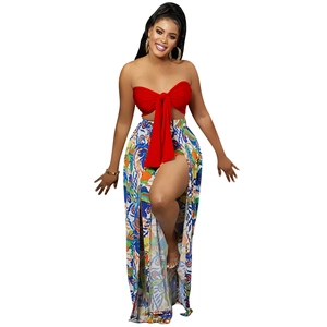 Detail of red bandeau top with bow and colorful high-slit abstract print trousers set