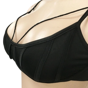 Primer plano detallado de un bustier negro con costuras verticales y tiras cruzadas finas