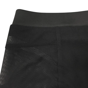 Detalle de retazos de malla negra y la cintura elástica de los pantalones