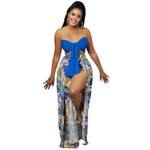 Detail of royal blue tube top with bow tie and high-slit floral printed maxi skirt
