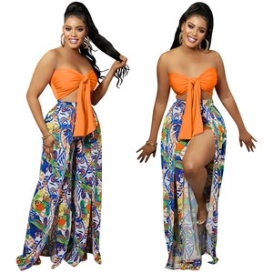 Detail showing bright orange tube top with lacing and paisley wide-leg pants with high slits