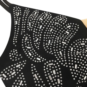 Detail of black mesh jumpsuit featuring silver rhinestone patterns and nude mesh inserts