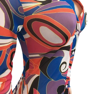 Detail of sheer mesh fabric with vibrant abstract geometric print and front button closure
