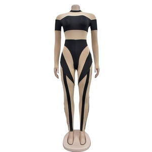 Detail eines langärmeligen Mesh-Catsuits mit schwarz-beigem geometrischem Patchwork