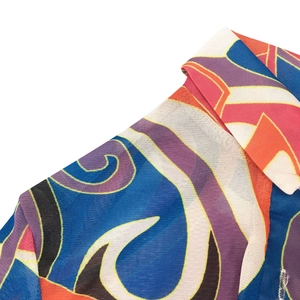 Macro detail of V-neck mesh dress featuring vibrant geometric abstract print