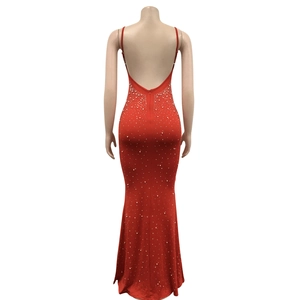 Detail of red backless bodycon dress featuring white bead embellishments and fishtail hem