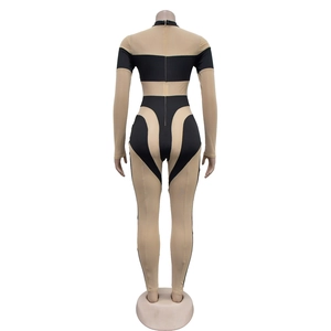 Rückansicht eines sexy Netz-Jumpsuits mit gelb-schwarzem Kontrastdesign und Reißverschluss hinten