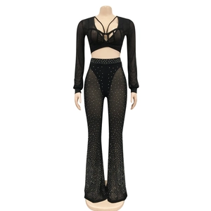 Detailed view of black sheer mesh outfit featuring sparkling rhinestones and flared leggings
