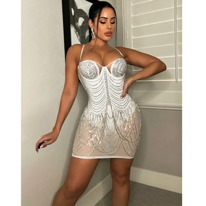 Detail of white bodycon dress with silver rhinestones and sparkling fringe tassels