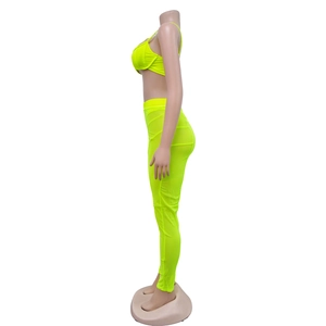 Vista lateral del conjunto verde neón con top corto y leggings de malla transparente