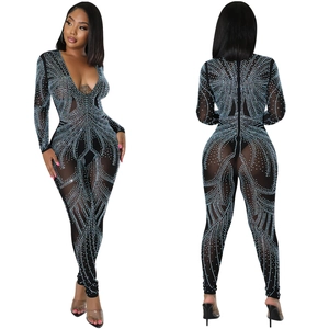 Close-up of sheer mesh jumpsuit with deep V-neck and radiant blue rhinestone patterns