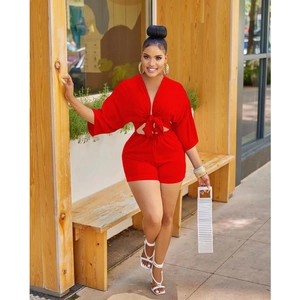 Outdoor shot of a woman in a red two-piece set with a tie-front top and high-waist shorts