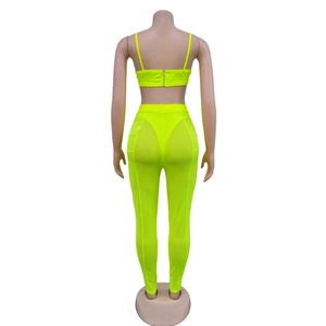 Detalle del conjunto de dos piezas amarillo neón con cremallera trasera y pantalón de malla